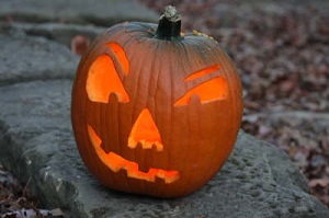A carved pumpkin with a smirk lit up by a candle